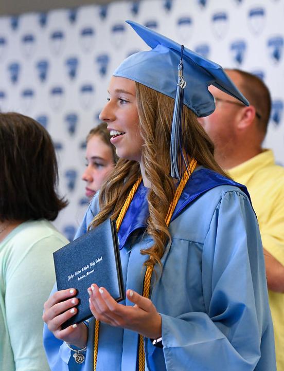 Olivia Barnes cheers for classmate Carter Wilkinson as he receives his diploma